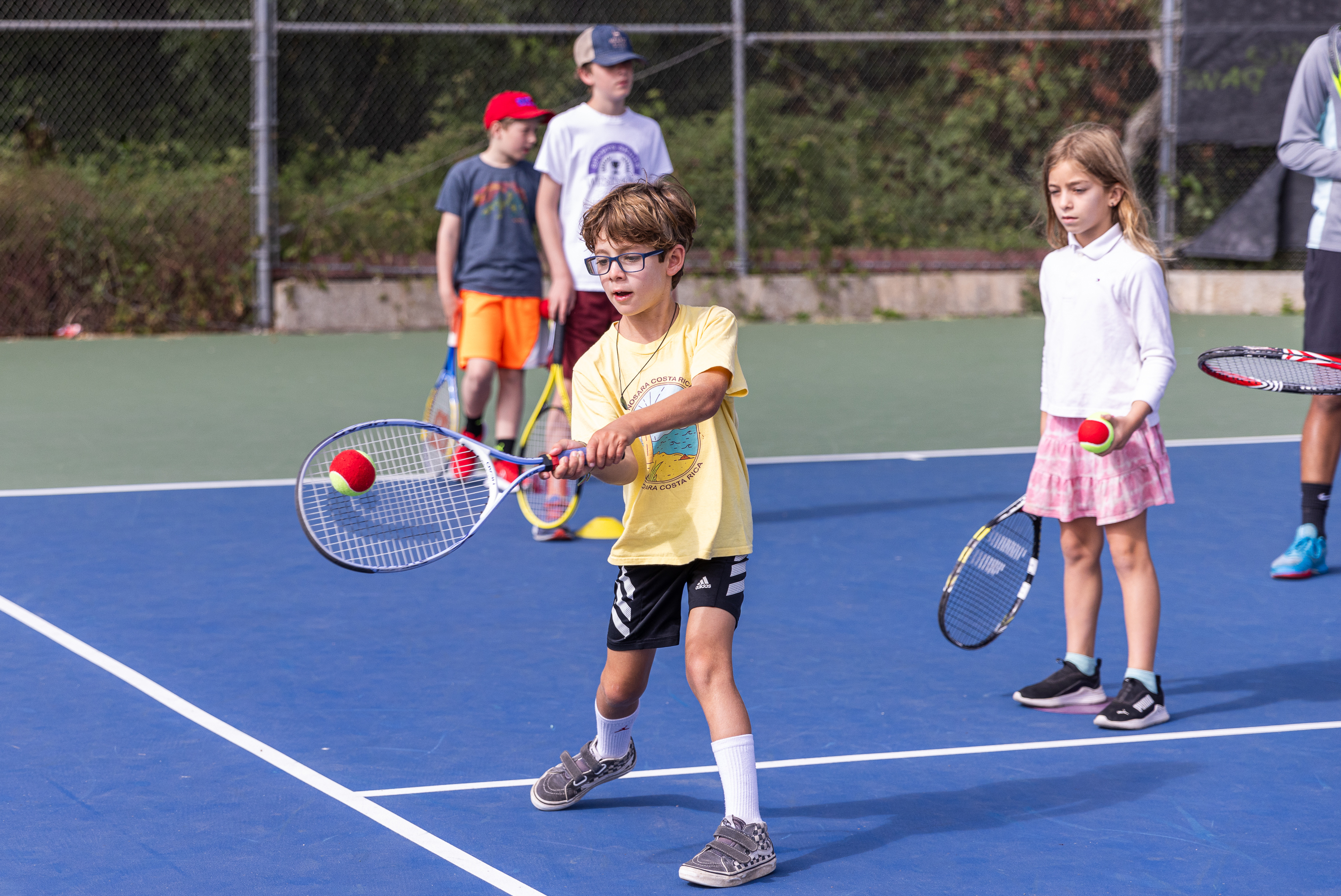 Tennis campers practice their forehand technique
