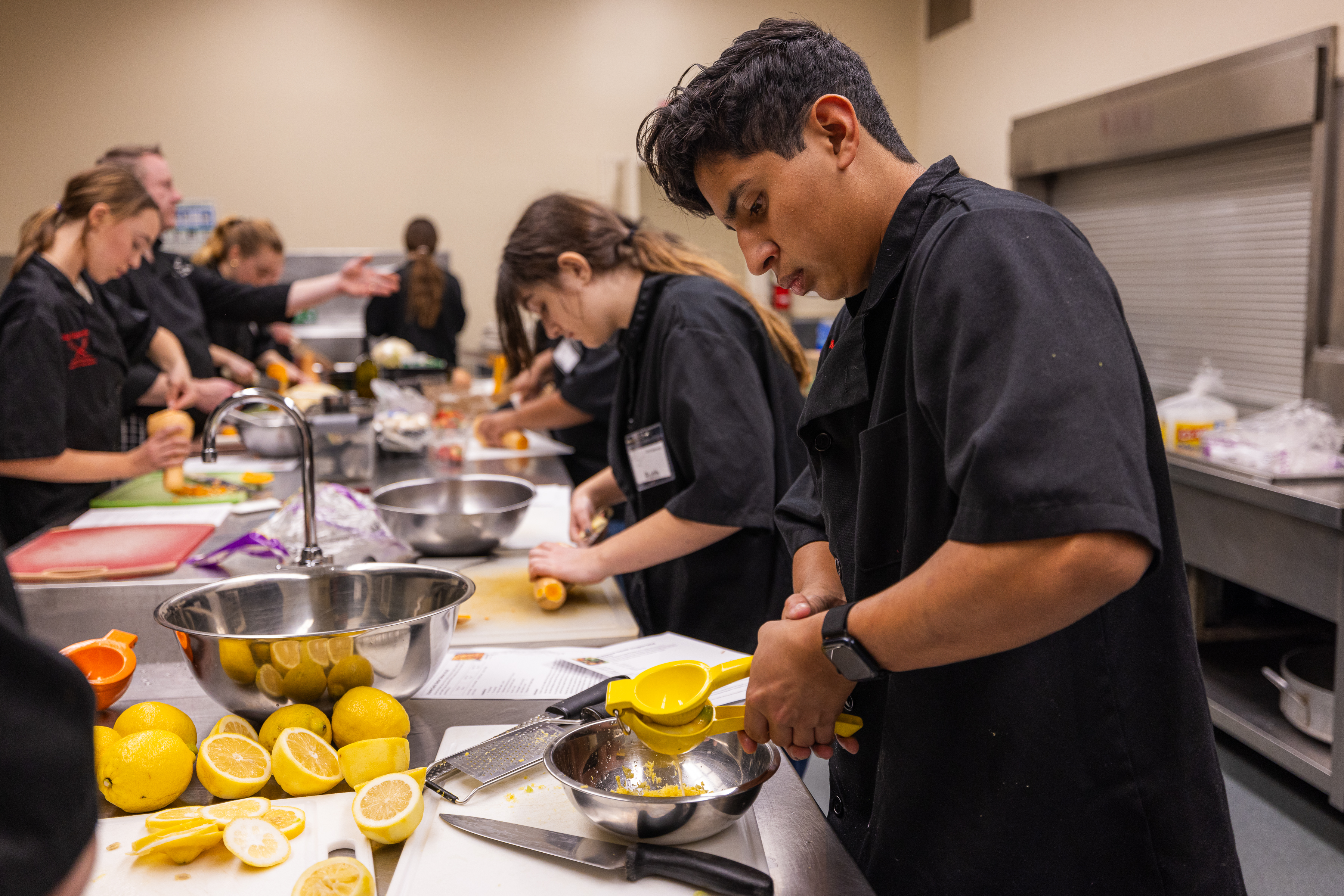 Chef Apprentices squeeze lemon juice and prepare squash