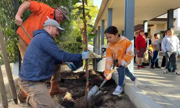 Adams Elementary students help staff plant a new tree on Arbor Day
