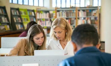 Two women using a computer in a library