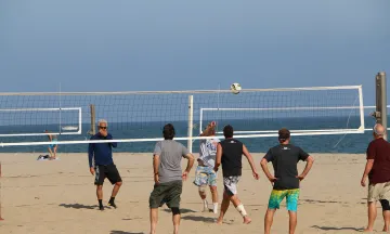 Community members play volleyball on East Beach