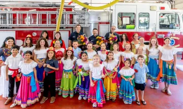 Los Niños de las Flores visit City Fire and pose for photo in front of a fire truck