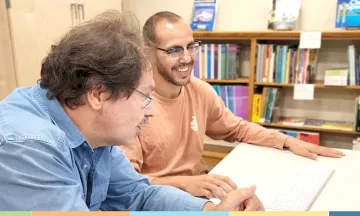 volunteer helping a learned at another computer