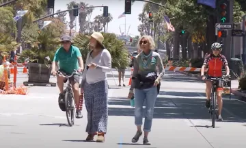 A group of people walking along State Street and riding bikes