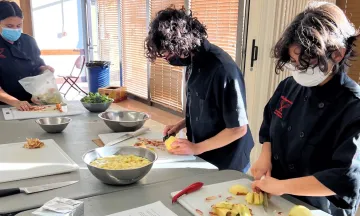 three students preparing food