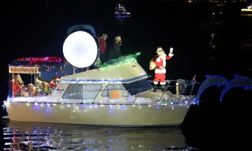 Santa on a boat decorated with Christmas lights