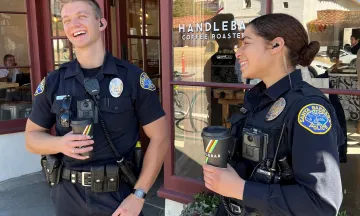 Two police officers holding coffee cups