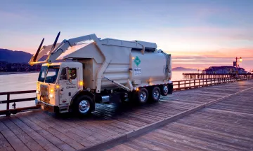 MarBorg trash truck driving down stearn's wharf with a sunset behind it