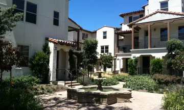 Image shows a housing development in Santa Barbara. The houses are white with surrounding greenery