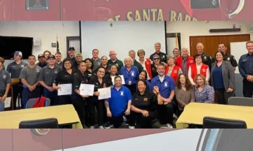 Image shows a large group of people smiling, men and women from all walks of life celebrating their achievement with City staff