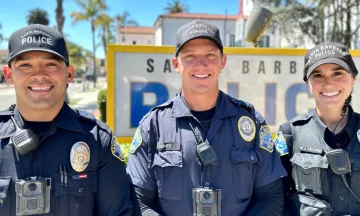 Image shows three officers, two men and a woman, smiling in uniform.