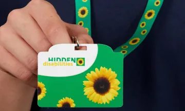 Image shows a green lanyard with sunflowers and a badge that reads "hidden disabilities"