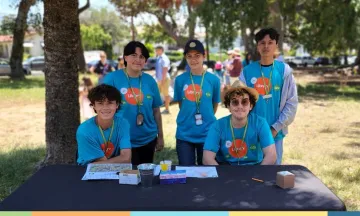 teens standing at a table outside