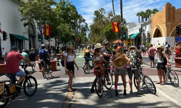 Image shows a large group of pedestrians on State Street walking and on bikes