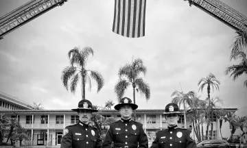 Three Officers Standing in front of the American Flag