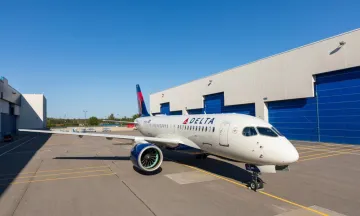 Delta airplane facing forward parked outside an airport hangar