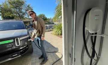Man charging his electric vehicle in driveway