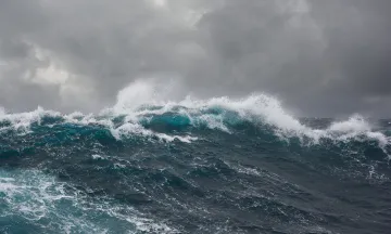 Large storm waves, deep blue with a gray sky