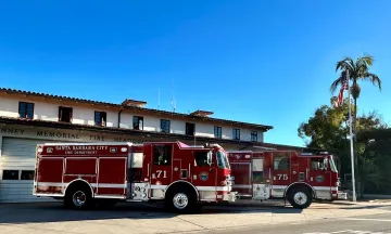Two brand new shiny red fire engines in front of Fire Department Station 1  on carrillo street