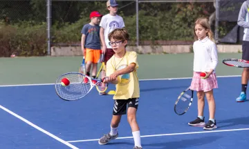 Tennis campers practice their forehand technique