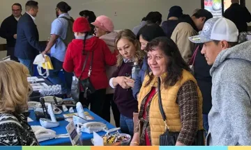 people standing around a table, speaking to staff