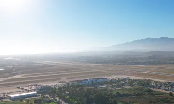 Aerial shot of Santa Barbara Airport, with the Terminal in the foreground and mountains in the background