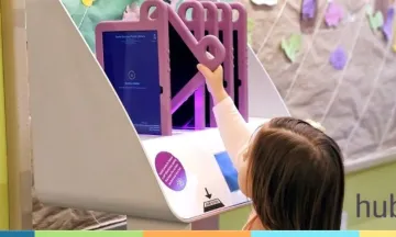 child reaching up to grab a tablet