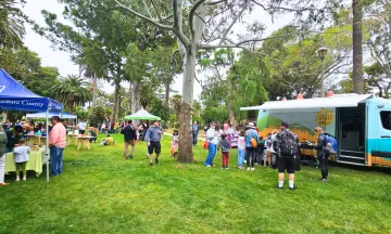 Summer Reading Kick Off at Alameda Park. Library on the Go van welcoming families enjoying a fun free event.