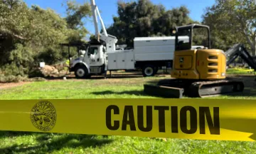 Oak Park Restoration construction equipment and caution tape in the work area.