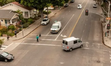 Milpas Intersection, pedestrians in crosswalk as vehicles share the intersection.