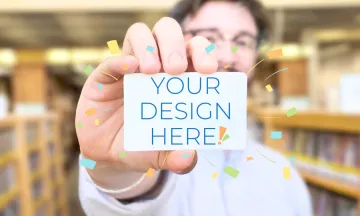 Staff member holding a blank library card that reads-Your Design Here