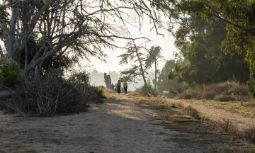 Picture of trail along Douglas Family Preserve and view of a couple on the cliffs overlooking the ocean