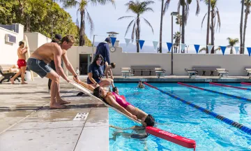 Lifeguard trainees practice water rescues at Los Baños del Mar.