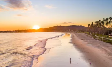 Photo of east beach at low tide view towards the sun setting over The Mesa