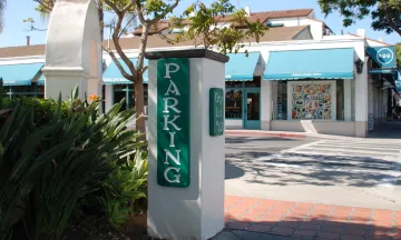 Entrance sign at Parking Lot 12 in Downtown Santa Barbara with businesses in the background