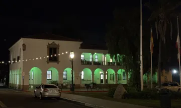 City Hall illuminated by green lights.