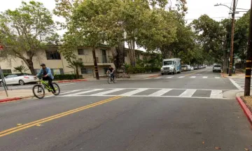 Intersection of Anapamu and San Andres Streets, cyclist sharing the road with vehicles.