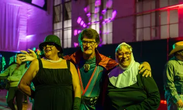 Three participants smiling at the camera in their Halloween costumes