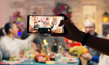 A photo being taken of a family holiday dinner with a mobile phone