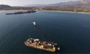 Barge near Stearns Wharf with Santa Barbara’s coastline in the background.