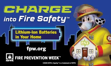 Sparky the Fire Dog, wearing yellow firefighter gear, holds a model of a home in his hands with a city skyline in the background. The image promotes Fire Prevention Week 2025 with the theme “Charge into Fire Safety,” highlighting lithium-ion battery safety at home.