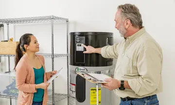 Contractor showing a customer a Heat Pump Water Heater (HPWH)