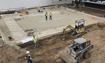 photo of construction projects downtown shows workers reviewing a site and machinery on the sides