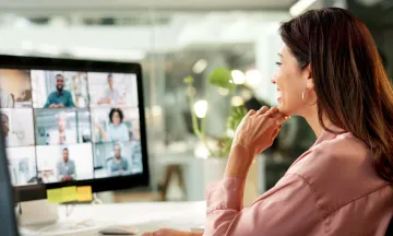 woman watching an online meeting at her desk