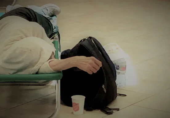 Photo of homeless person lying down with backpack
