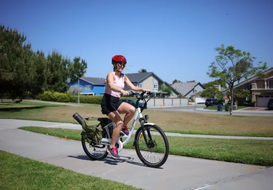 Woman in a helmet riding a bicycle along a path.