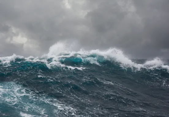 Large storm waves, deep blue with a gray sky