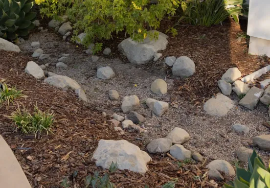 Photo of downspout emptying to gravel that helps with storm water management  and run off.