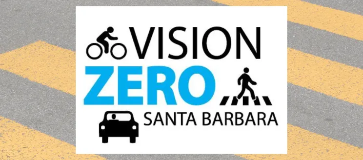 This image shows a crosswalk with a black and blue graphic that says "Vision Zero Santa Barbara," with illustrations of a biker, pedestrian and a car. 