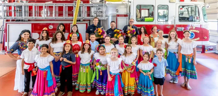Los Niños de las Flores visit City Fire and pose for photo in front of a fire truck